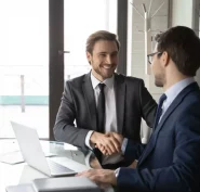Smiling businessmen shake hands, commercial real estate broker services are an asset concept